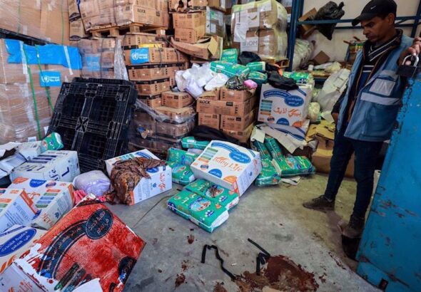A UNRWA staff stands near a pool of blood at a UNRWA warehouse and distribution center in Rafah, in the southern Gaza strip, following an Israeli strike on March, 13, 2024. Photo: AFP.