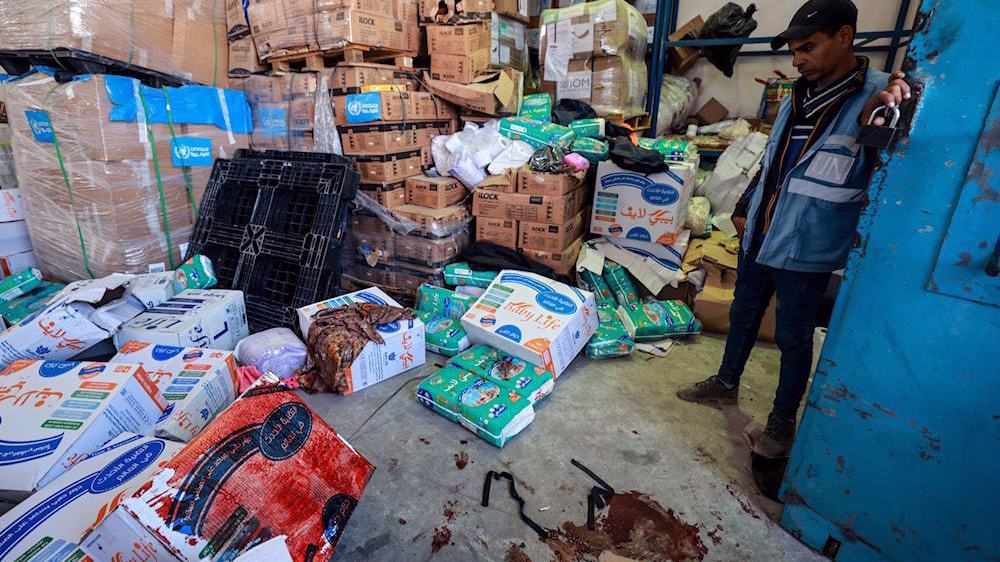 A UNRWA staff stands near a pool of blood at a UNRWA warehouse and distribution center in Rafah, in the southern Gaza strip, following an Israeli strike on March, 13, 2024. Photo: AFP.