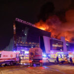 Vehicles of Russian emergency services are parked near the burning Crocus City Hall concert venue following a reported shooting incident, outside Moscow, on Mar. 22, 2024. Photo: Reuters.