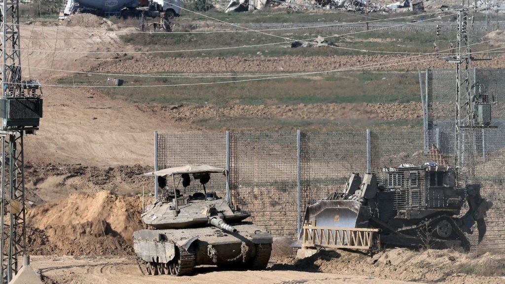A tank and an armored bulldozer roll along the Israel-Gaza border. Photo: Jack Guez/Agence France-Presse/Getty Images.