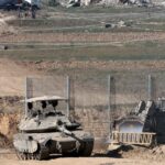 A tank and an armored bulldozer roll along the Israel-Gaza border. Photo: Jack Guez/Agence France-Presse/Getty Images.