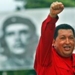 The late president and revolutionary leader of Venezuela, Comandante Hugo Chávez, pictured during a political rally raising his fist, with a billboard featuring Che Guevara in the background. Photo: Sven Creutzmann/Gettyimages.ru/File photo.