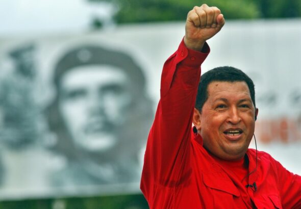 The late president and revolutionary leader of Venezuela, Comandante Hugo Chávez, pictured during a political rally raising his fist, with a billboard featuring Che Guevara in the background. Photo: Sven Creutzmann/Gettyimages.ru/File photo.