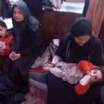 Displaced Palestinian women take care of their children inside a tent in Rafah in the southern Gaza Strip on 7 March 2024, on the eve of International Women's Day, amid Israel's ongoing genocidal war on the besieged strip. Photo: AFP.