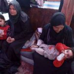 Displaced Palestinian women take care of their children inside a tent in Rafah in the southern Gaza Strip on 7 March 2024, on the eve of International Women's Day, amid Israel's ongoing genocidal war on the besieged strip. Photo: AFP.