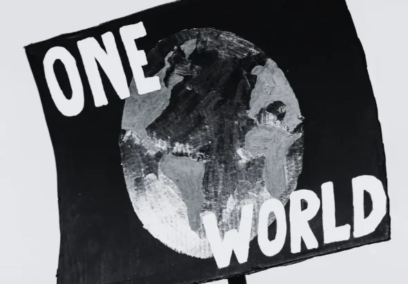 Banner with a painted globe and a caption that reads "one world." Photo: Markus Spiske/Pexels.