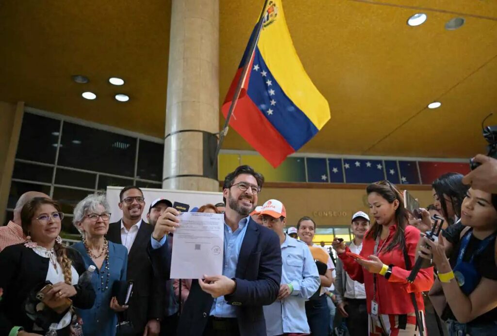 Far-right politician Daniel Ceballos showing his presidential candidate registration certificate at the entrance of the National Electoral Council (CNE) in Caracas on Thursday, March 21, 2024. Photo: AFP.