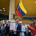 Far-right politician Daniel Ceballos showing his presidential candidate registration certificate at the entrance of the National Electoral Council (CNE) in Caracas on Thursday, March 21, 2024. Photo: AFP.