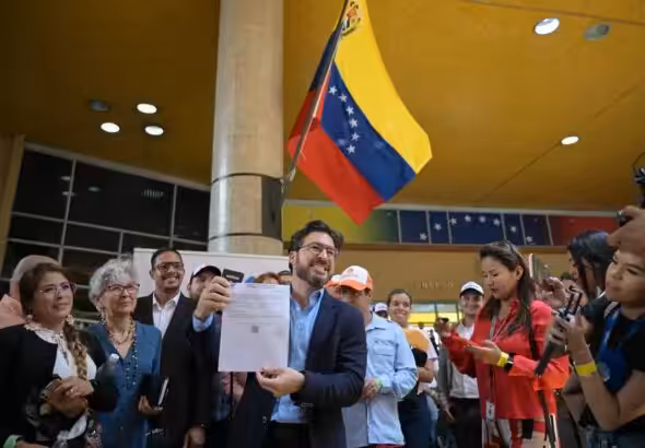 Far-right politician Daniel Ceballos showing his presidential candidate registration certificate at the entrance of the National Electoral Council (CNE) in Caracas on Thursday, March 21, 2024. Photo: AFP.