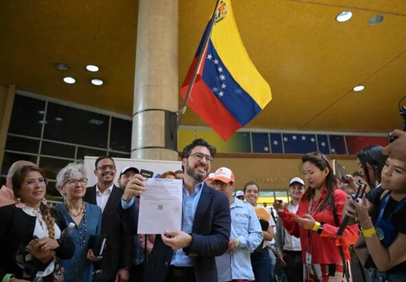 Far-right politician Daniel Ceballos showing his presidential candidate registration certificate at the entrance of the National Electoral Council (CNE) in Caracas on Thursday, March 21, 2024. Photo: AFP.