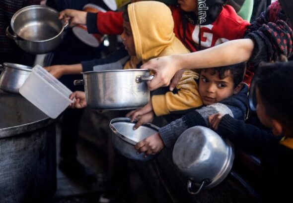 Palestinian children wait to receive food cooked by a charity kitchen amid shortages of food supplies, in Rafah, in the southern Gaza Strip, March 5, 2024. Photo: Mohammed Salem/Reuters.