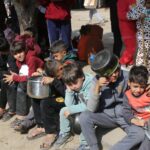 Dozens of starving children lined up to receive what little aid is able to arrive in Gaza. Photo: UNRWA.