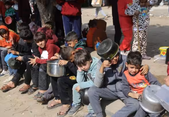 Dozens of starving children lined up to receive what little aid is able to arrive in Gaza. Photo: UNRWA.