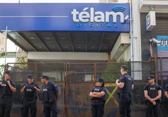 Argentina's Federal Police agents (PFA) barricade the entrance to Télam news agency's headquarters with a security fence. Photo: Adrián Escándar via Infobae.