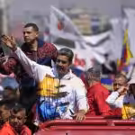 Venezuelan President Nicolas Maduro waves to supporters as he and his wife Cilia Flores are driven to the National Election Commission (CNE) to formalize his candidacy to run again for president in Caracas, Venezuela, Monday, March 25, 2024. Photo: Matias Delacroix/AP.