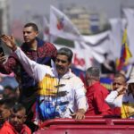 Venezuelan President Nicolas Maduro waves to supporters as he and his wife Cilia Flores are driven to the National Election Commission (CNE) to formalize his candidacy to run again for president in Caracas, Venezuela, Monday, March 25, 2024. Photo: Matias Delacroix/AP.