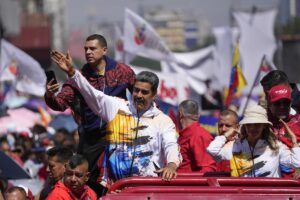 Venezuelan President Nicolas Maduro waves to supporters as he and his wife Cilia Flores are driven to the National Election Commission (CNE) to formalize his candidacy to run again for president in Caracas, Venezuela, Monday, March 25, 2024. Photo: Matias Delacroix/AP.