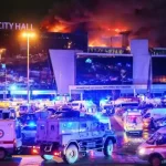 Vehicles of Russian emergency services are parked near the burning Crocus City Hall concert venue following a reported shooting incident, outside Moscow, on Mar. 22, 2024. Photo: AlahedNews/File photo.