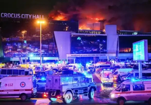 Vehicles of Russian emergency services are parked near the burning Crocus City Hall concert venue following a reported shooting incident, outside Moscow, on Mar. 22, 2024. Photo: AlahedNews/File photo.
