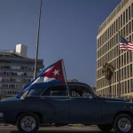 A classic American car flying a Cuban flag drives past the US embassy during a rally calling for the end of the US blockade against Cuba. Photo: AP/Ramon Espinosa.