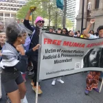 People marching through the streets of Philadelphia with posters demanding freedom for Mumia Abu-Jamal on April 24, 2024. Photos: Stephen Millies/SLL.