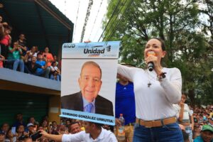 Venezuelan far-right politician María Corina Machado campaigning in the Venezuelan countryside, holding a poster with the photo of Edmundo Gonzalez Urrutia. Photo: X/@alcaldeledezma.