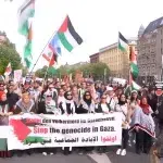 Pro-Palestinian protesters in the streets of Berlin holding a banner that reads “Stop the Genocide in Gaza,” on Sunday, April 14, 2024. Photo: PressTV footage screenshot.