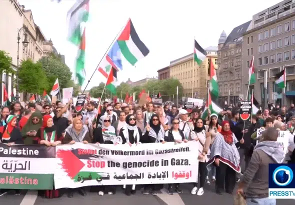 Pro-Palestinian protesters in the streets of Berlin holding a banner that reads “Stop the Genocide in Gaza,” on Sunday, April 14, 2024. Photo: PressTV footage screenshot.