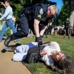A police officer violently restrains a demonstrator at Emory University campus during a pro-Palestine protest on April 24, 2024, in Atlanta, United States. Photo: Mike Stewart/AP.
