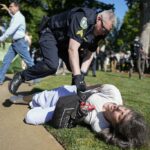 A police officer violently restrains a demonstrator at Emory University campus during a pro-Palestine protest on April 24, 2024, in Atlanta, United States. Photo: Mike Stewart/AP.
