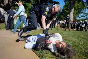 A police officer violently restrains a demonstrator at Emory University campus during a pro-Palestine protest on April 24, 2024, in Atlanta, United States. Photo: Mike Stewart/AP.