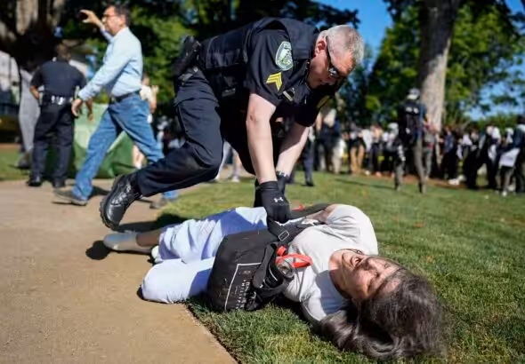 A police officer violently restrains a demonstrator at Emory University campus during a pro-Palestine protest on April 24, 2024, in Atlanta, United States. Photo: Mike Stewart/AP.