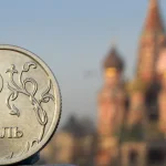 Photo composition: A Russian ruble coin (front) and St. Basil cathedral in central Moscow (background). Photo: Alexander Nemenov/AFP.