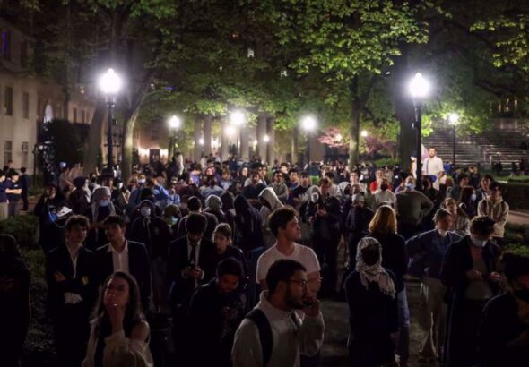 People react as protesters link arms outside Hamilton Hall barricading students inside the building at Columbia University in New York City, US, April 30, 2024. Photo: Reuters.