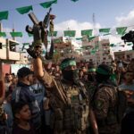 A Palestinian Resistance fighter from al-Qassam Brigades holds a rifle seized from Israeli occupation forces during an arms show for the group at the Nuseirat refugee camp. central Gaza Strip, Palestine , on June 30, 2023. Photo: AP.