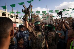 A Palestinian Resistance fighter from al-Qassam Brigades holds a rifle seized from Israeli occupation forces during an arms show for the group at the Nuseirat refugee camp. central Gaza Strip, Palestine , on June 30, 2023. Photo: AP.
