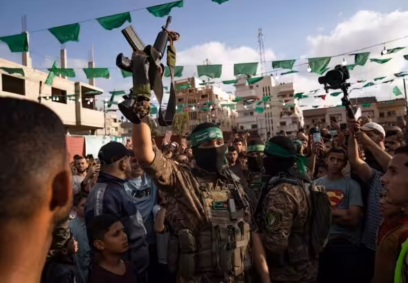 A Palestinian Resistance fighter from al-Qassam Brigades holds a rifle seized from Israeli occupation forces during an arms show for the group at the Nuseirat refugee camp. central Gaza Strip, Palestine , on June 30, 2023. Photo: AP.