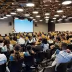 A packed room of Israel Defense Forces (IDF) soldiers attending a conference at a Microsoft Israel R&D center. The photo was publicly shared by the Lotem technology unit of the IDF’s Computer Services Directorate on August 2, 2023 and shows a conference led by the unit’s Shahar component the previous day, with roughly 150 soldiers in attendance. Microsoft’s logo can be partially seen on the center of the left side of the image and the title of the displayed slide translates from Hebrew to “the 10 commandments of the digital.” The second such commandment can be seen to be “RTFM,” meaning: “Read The Fucking Manual.”