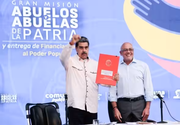 Venezuelan President Nicolás Maduro, accompanied by National Assembly President Jorge Rodríguez, holds the document of the newly signed Law for the Protection of Pensions Against the Blockade, May 8, 2024. Photo: Presidential Press.