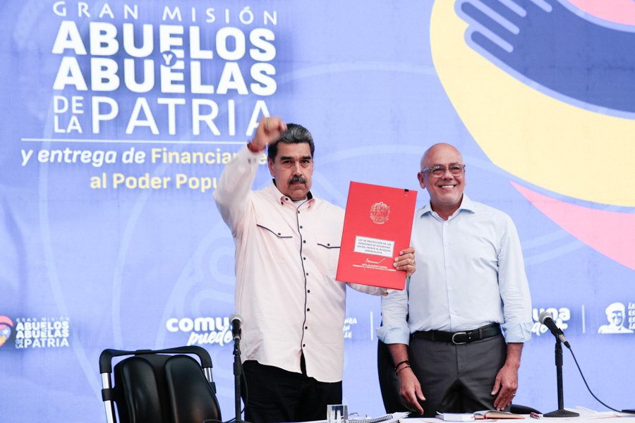 Venezuelan President Nicolás Maduro, accompanied by National Assembly President Jorge Rodríguez, holds the document of the newly signed Law for the Protection of Pensions Against the Blockade, May 8, 2024. Photo: Presidential Press.