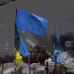 A soldier stands behind barricades on which the flags of European Union and Ukraine fly, amid artillery strikes. Illustration: Hadi Dbouk/Al-Mayadeen.