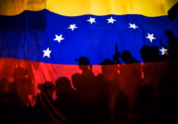 Opposition protesters, seen behind a Venezuelan flag, during the violent opposition protests known as "guarimbas" in 2017. Photo: Juan Barreto/AFP/File photo.