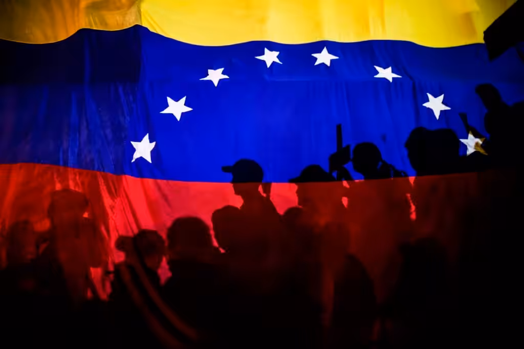 Opposition protesters, seen behind a Venezuelan flag, during the violent opposition protests known as "guarimbas" in 2017. Photo: Juan Barreto/AFP/File photo.