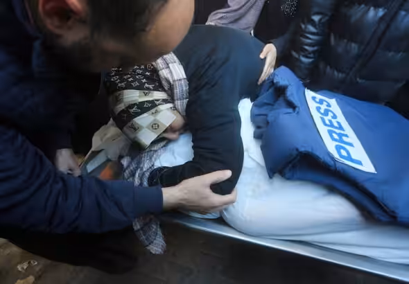 A relative mourns Palestinian journalist Akram Al-Shafi'i, killed in the Israeli bombarment of the Gaza Strip, in a morgue of the European Hospital in Rafah, occupied Palestine, January 6, 2024. Photo: AP.