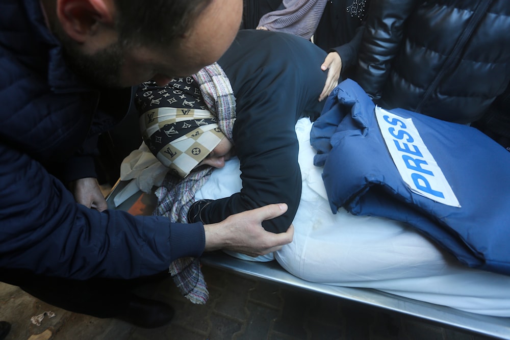 A relative mourns Palestinian journalist Akram Al-Shafi'i, killed in the Israeli bombarment of the Gaza Strip, in a morgue of the European Hospital in Rafah, occupied Palestine, January 6, 2024. Photo: AP.