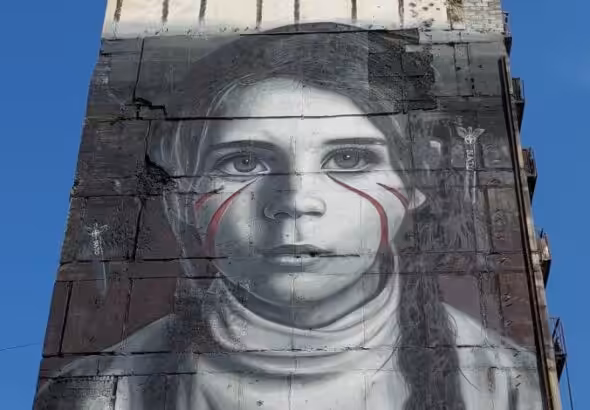 Giant mural of a girl in the side of a building. Photo: International reporters/file photo.