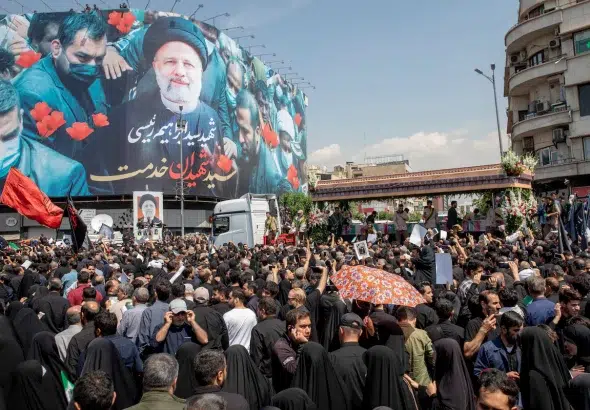 Iranians follow a truck carrying coffins of the late President Ebrahim Raisi and his companions, who were killed in a helicopter crash, during a funeral ceremony for them on May 22, 2024 in Tehran, Iran. Photo: Majid Saeedi/Getty Images.