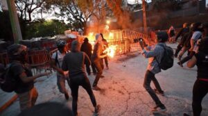 An angry pro-Palestinian protester hurls a Molotov cocktail towards the Israeli embassy in Mexico City, Mexico. Photo: AFP.