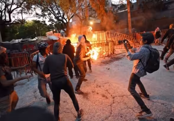 An angry pro-Palestinian protester hurls a Molotov cocktail towards the Israeli embassy in Mexico City, Mexico. Photo: AFP.