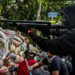 A so called "resistance fighter," aims an improvised weapon in the city of Yangon. Photo: Stringer/Getty.
